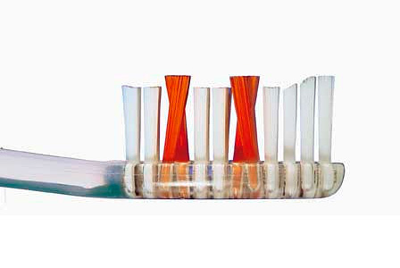 La foto muestra un ejemplo de un cepillo de dientes con mechones de cerdas de diferentes longitudes y su disposición en forma de x